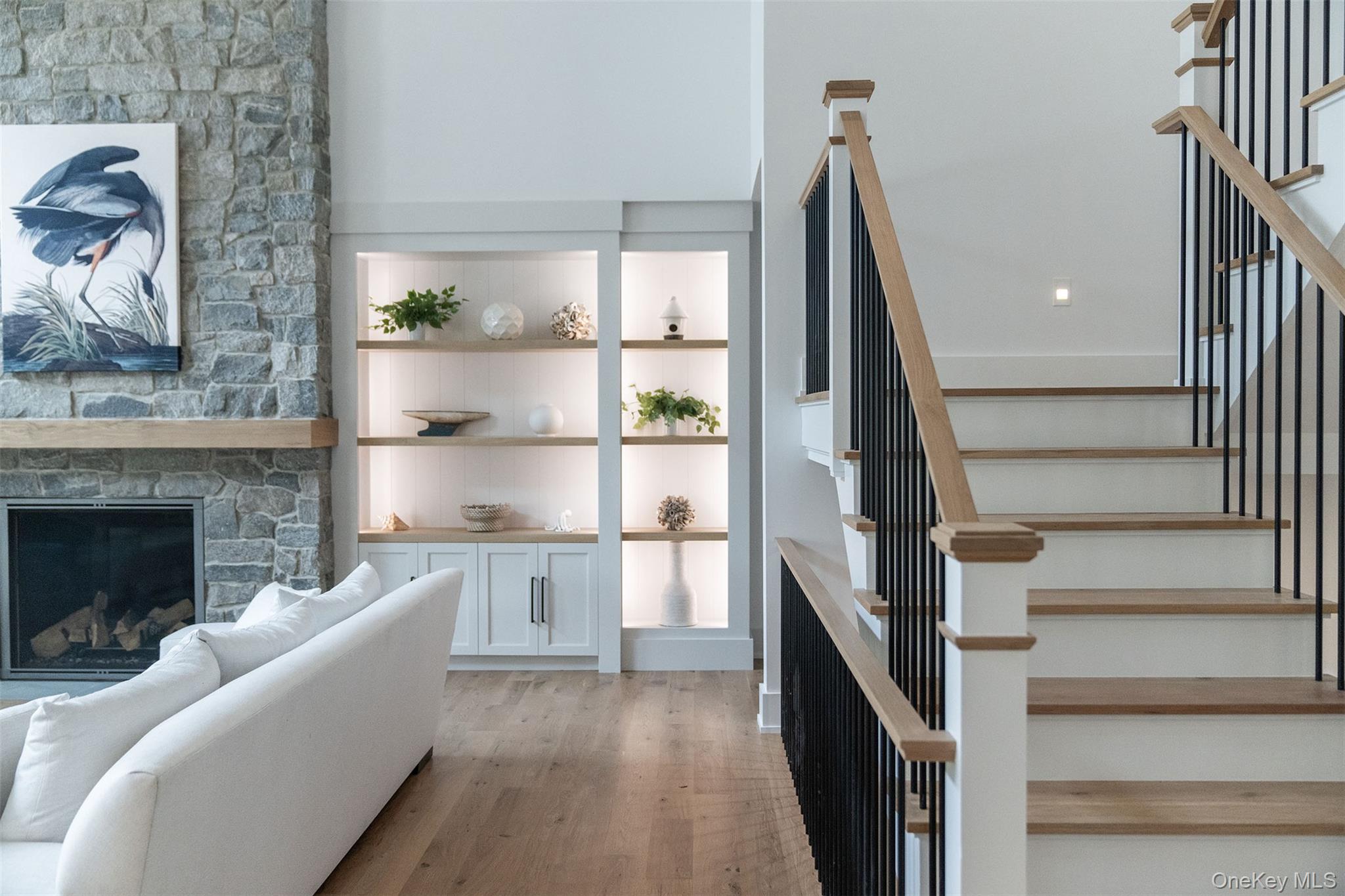 465 Ripple Water Lane Southold, NY 11971 - Photo 34 of 46 Stairway featuring wood finished floors and a stone fireplace