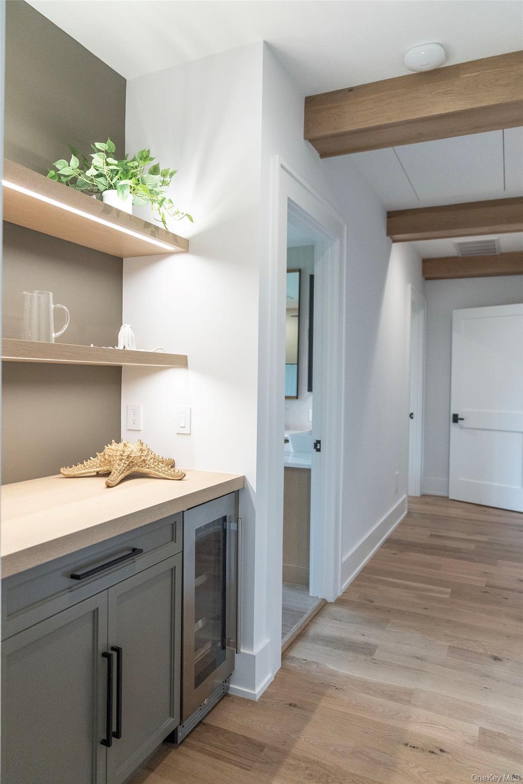 465 Ripple Water Lane Southold, NY 11971 - Photo 39 of 47 Bar area with open shelves, gray cabinets, light wood-type flooring, beverage cooler, and beam ceiling