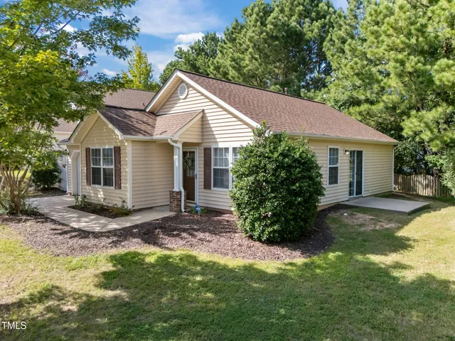 a view of a house with a yard and large tree