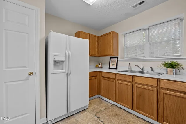 a kitchen with stainless steel appliances granite countertop a refrigerator and a sink