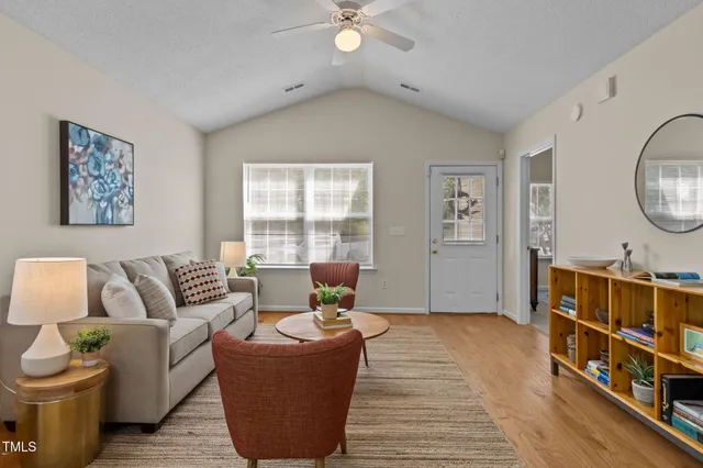 a living room with furniture and a wooden floor