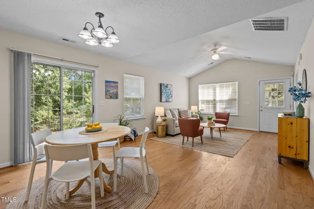 a view of a dining room with furniture a chandelier and wooden floor