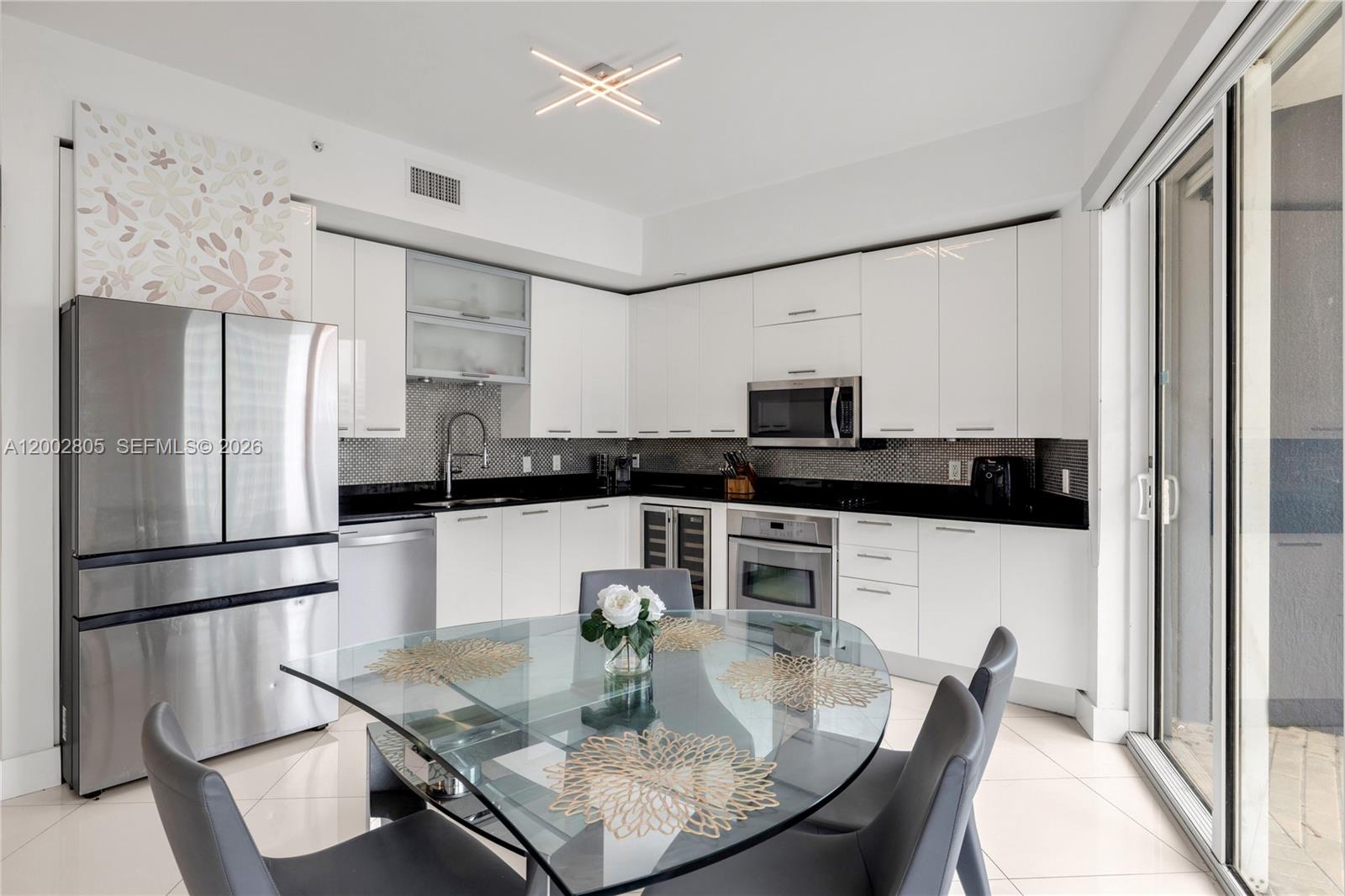 60 Southwest 13th Street, Unit 1124 Miami, FL 33130 - Photo 10 of 30 a kitchen with stainless steel appliances granite countertop a refrigerator a stove a sink and a refrigerator with wooden floor