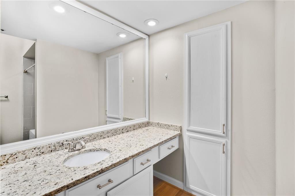 3777 Peachtree Road Northeast, Unit 1529 Atlanta, GA 30319 - Photo 17 of 45 a bathroom with a granite countertop sink and a mirror