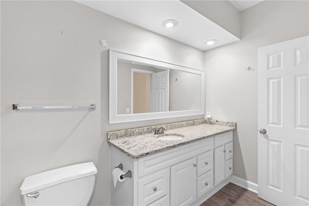 3777 Peachtree Road Northeast, Unit 1529 Atlanta, GA 30319 - Photo 21 of 45 a bathroom with a granite countertop sink a toilet and a mirror