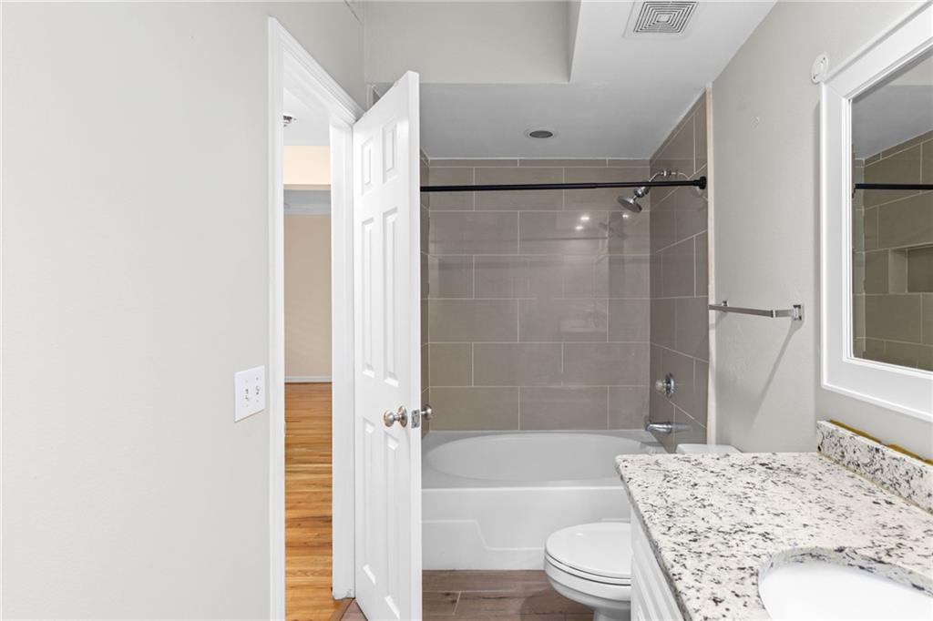 3777 Peachtree Road Northeast, Unit 1529 Atlanta, GA 30319 - Photo 22 of 45 a bathroom with a granite countertop bathtub shower sink vanity and toilet