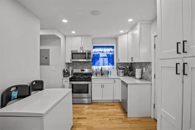 a kitchen with white cabinets and stainless steel appliances