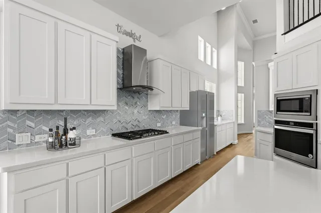 a kitchen with stainless steel appliances white cabinets and a stove