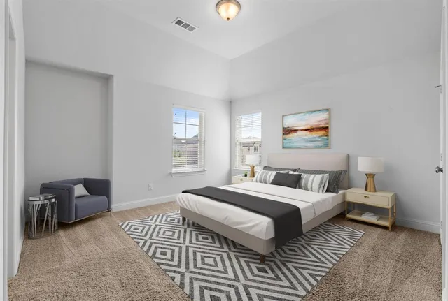 a bedroom with a bed and a lamp on dresser