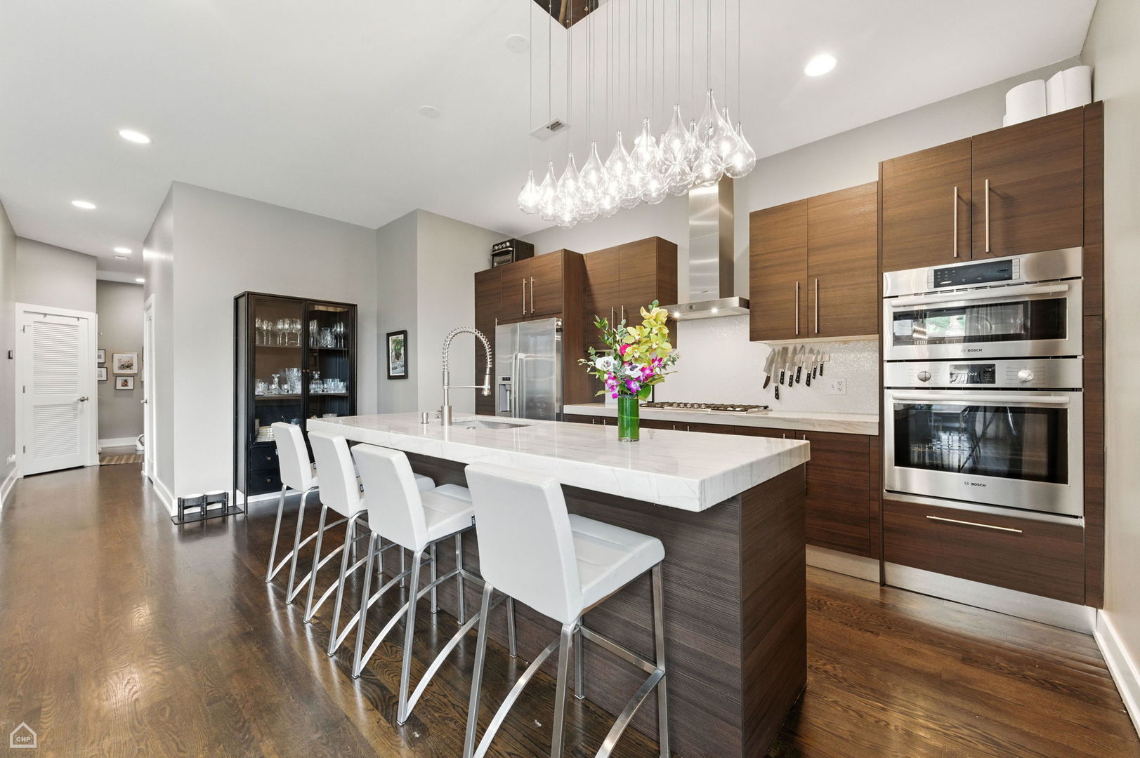 1312 West Madison Street, Unit 3A Chicago, IL 60607 - Photo 4 of 21 a kitchen with stainless steel appliances kitchen island granite countertop a table chairs and a refrigerator