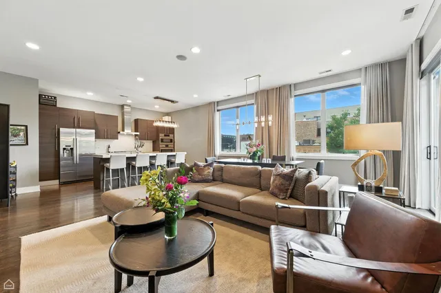 a living room with furniture kitchen and a large window