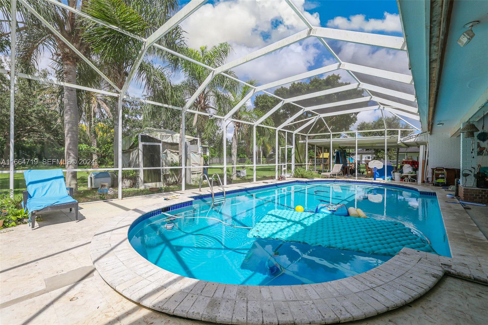 17421 Southwest 300th Street Homestead, FL 33030 - Photo 40 of 62 a view of a swimming pool with a lounge chairs