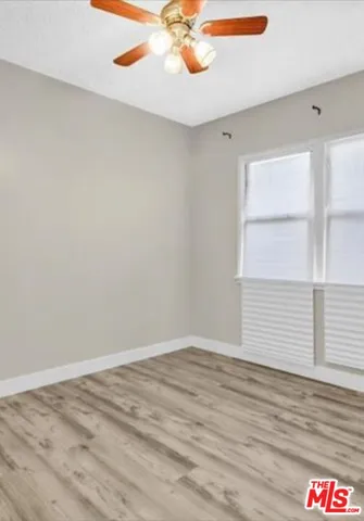a view of an empty room window and wooden floor