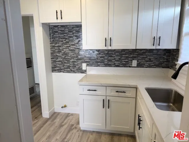 a view of a kitchen with white cabinets