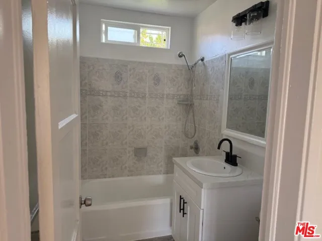 a bathroom with a sink a mirror and shower
