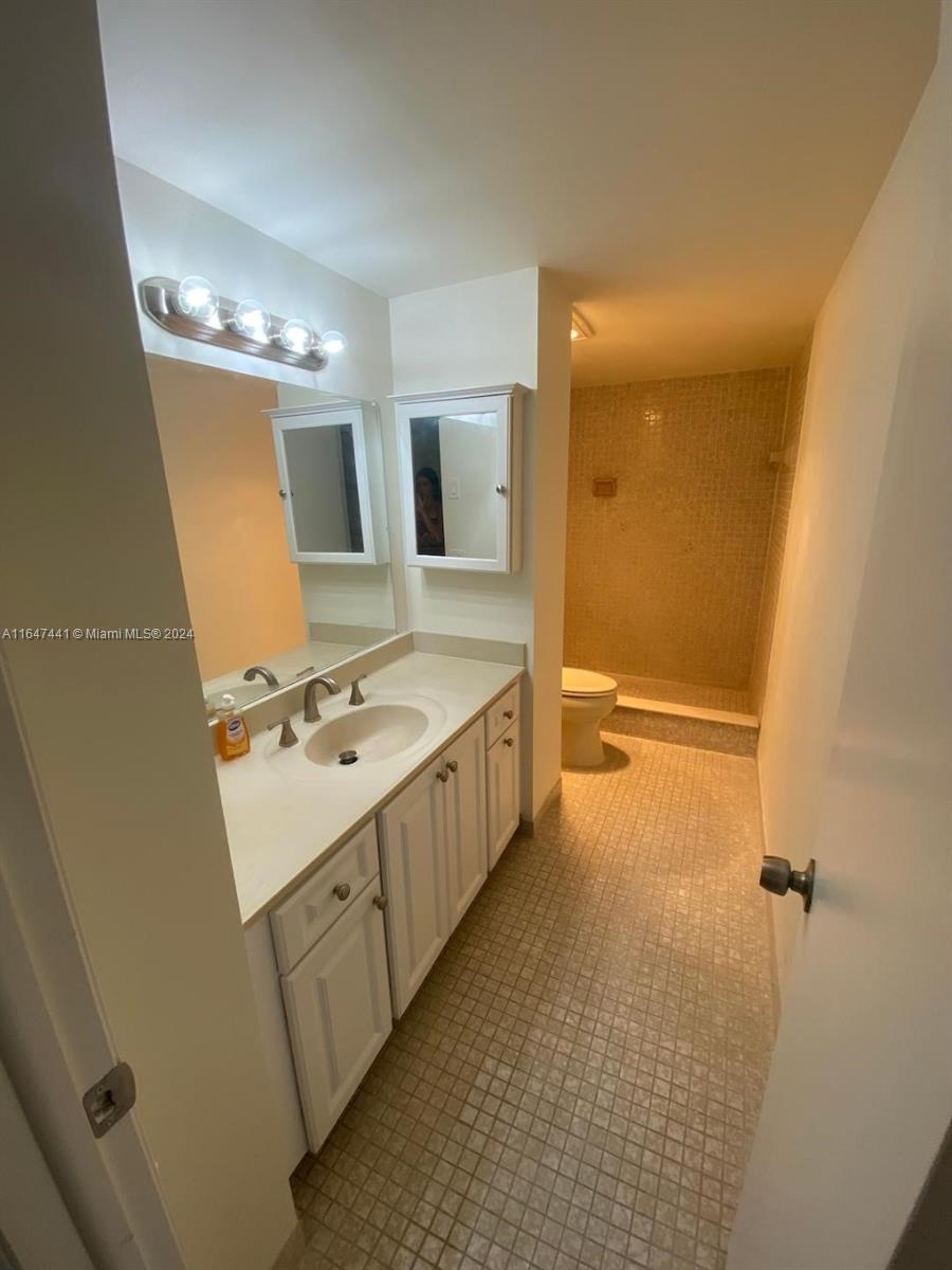 3850 Washington Street, Unit 1110 Hollywood, FL 33021 - Photo 17 of 29 a bathroom with a sink a toilet and mirror