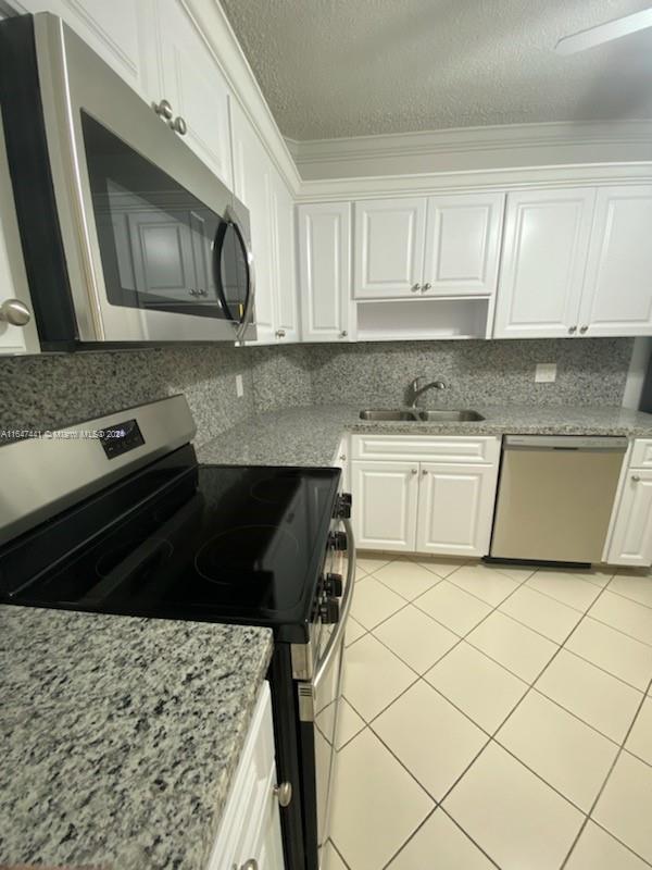 3850 Washington Street, Unit 1110 Hollywood, FL 33021 - Photo 5 of 29 a kitchen with granite countertop white cabinets and black appliances