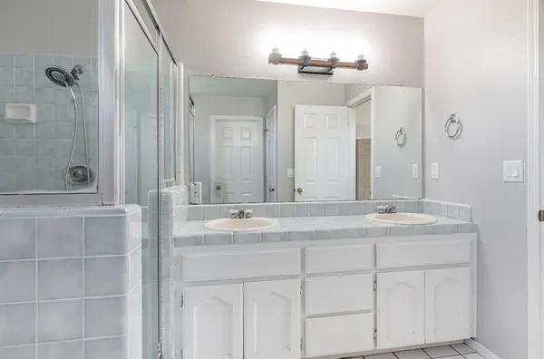 a bathroom with a double vanity sink and mirror