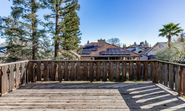 a view of a house with a small yard and wooden fence