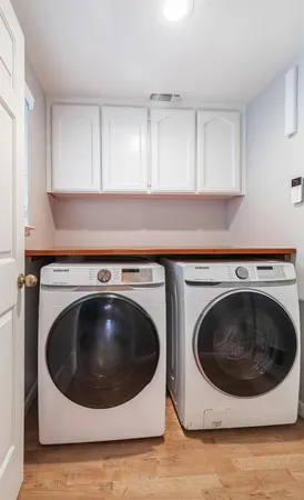 a utility room with wooden floor sink and cabinets