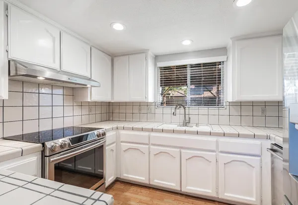 a kitchen with granite countertop a sink stainless steel appliances and cabinets