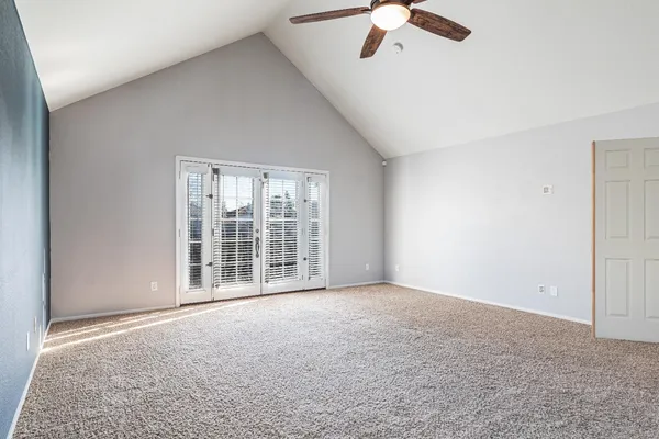 an empty room with chandelier fan