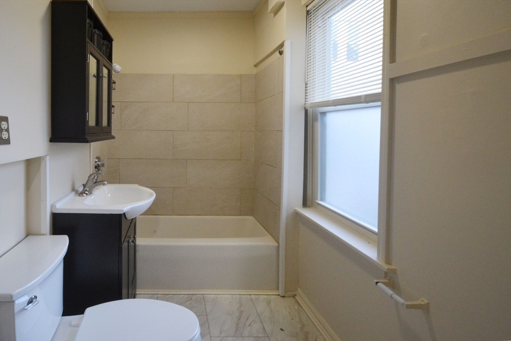 143 Arlington Street, Unit 1 Framingham, MA 01702 - Photo 11 of 20 a bathroom with a sink a toilet and shower