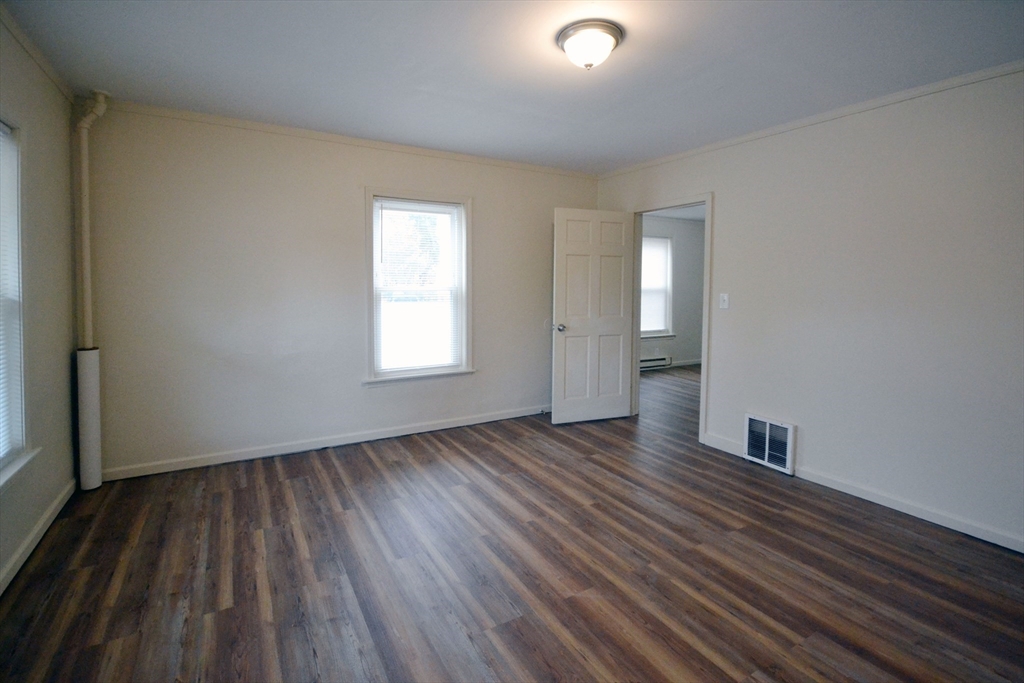 143 Arlington Street, Unit 1 Framingham, MA 01702 - Photo 16 of 20 an empty room with wooden floor and windows