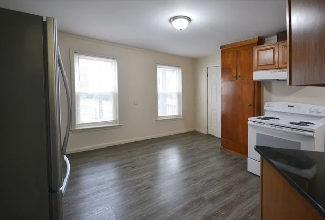 an empty room with wooden floor and a window