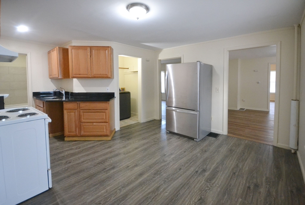 143 Arlington Street, Unit 1 Framingham, MA 01702 - Photo 6 of 20 a kitchen with granite countertop a refrigerator and a stove top oven
