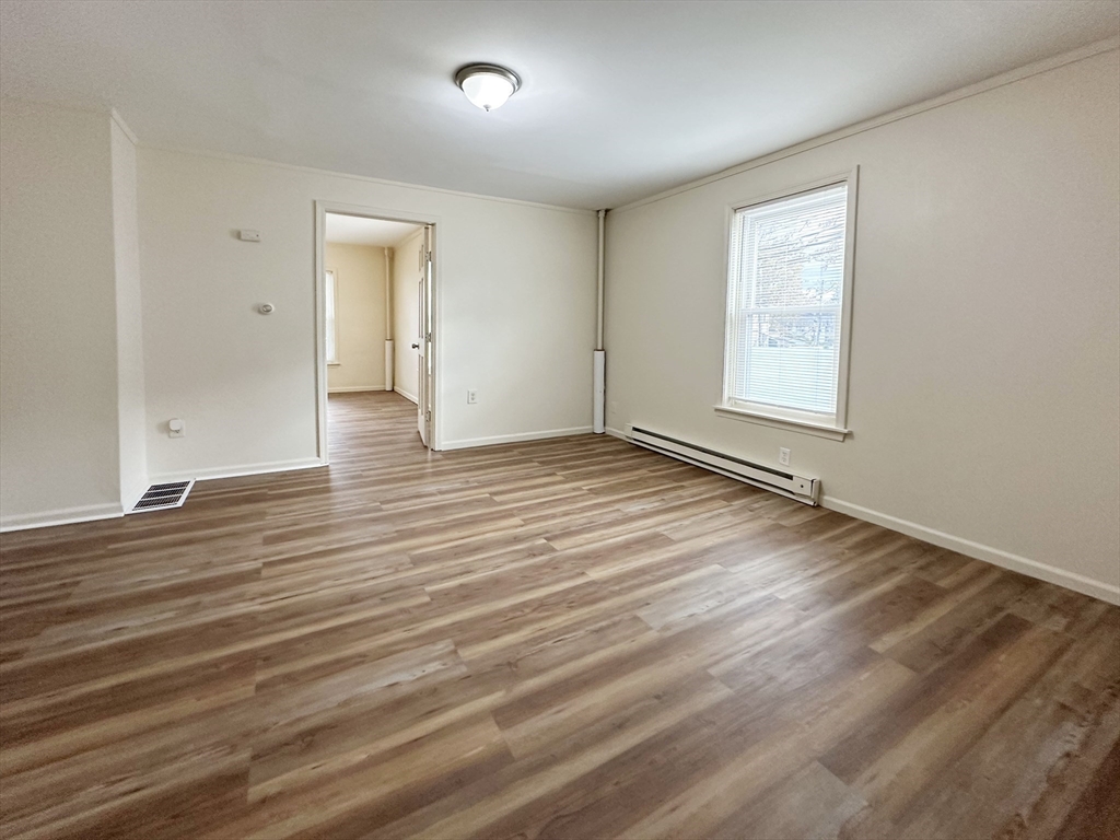 143 Arlington Street, Unit 1 Framingham, MA 01702 - Photo 9 of 20 an empty room with wooden floor and windows