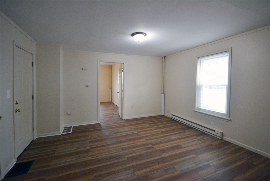 143 Arlington Street, Unit 1 Framingham, MA 01702 - Photo 10 of 20 an empty room with wooden floor and windows