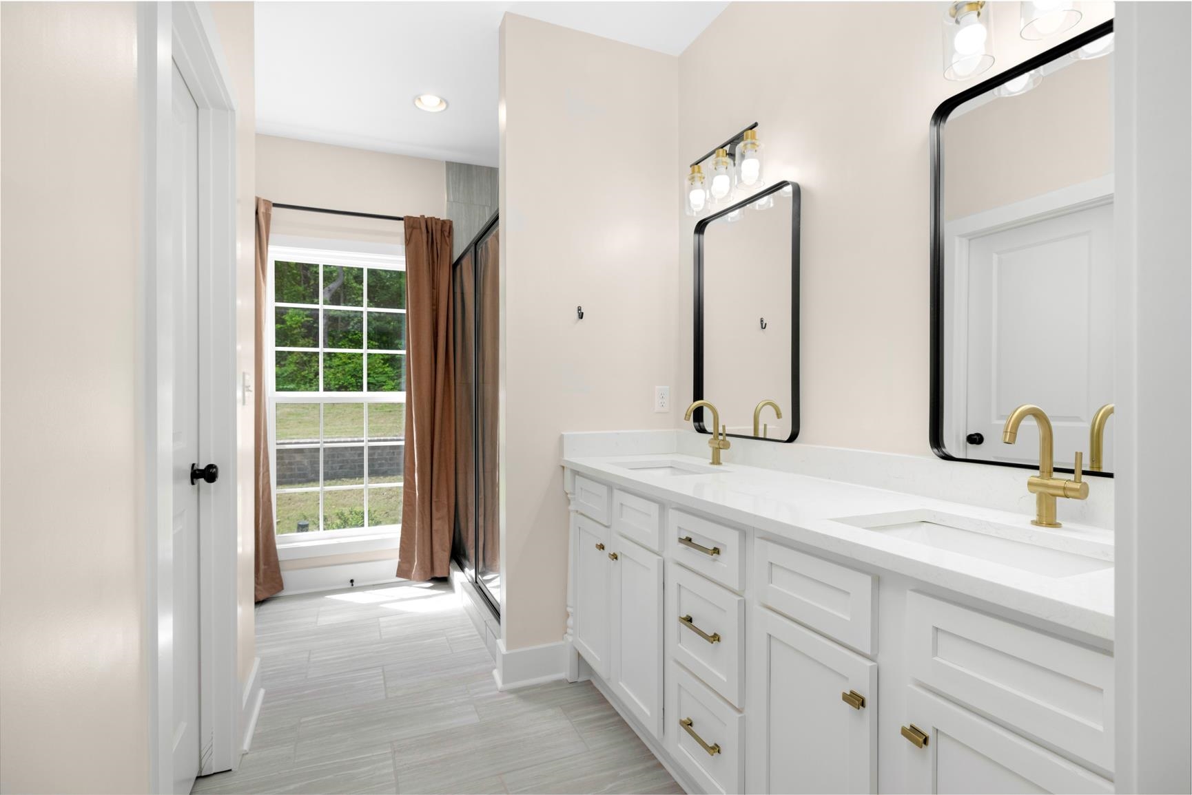 5702 Spring Lake Road Memphis, TN 38135 - Photo 24 of 40 Double vanity featuring white cabinetry, gold-finish hardware, and a light-toned countertop