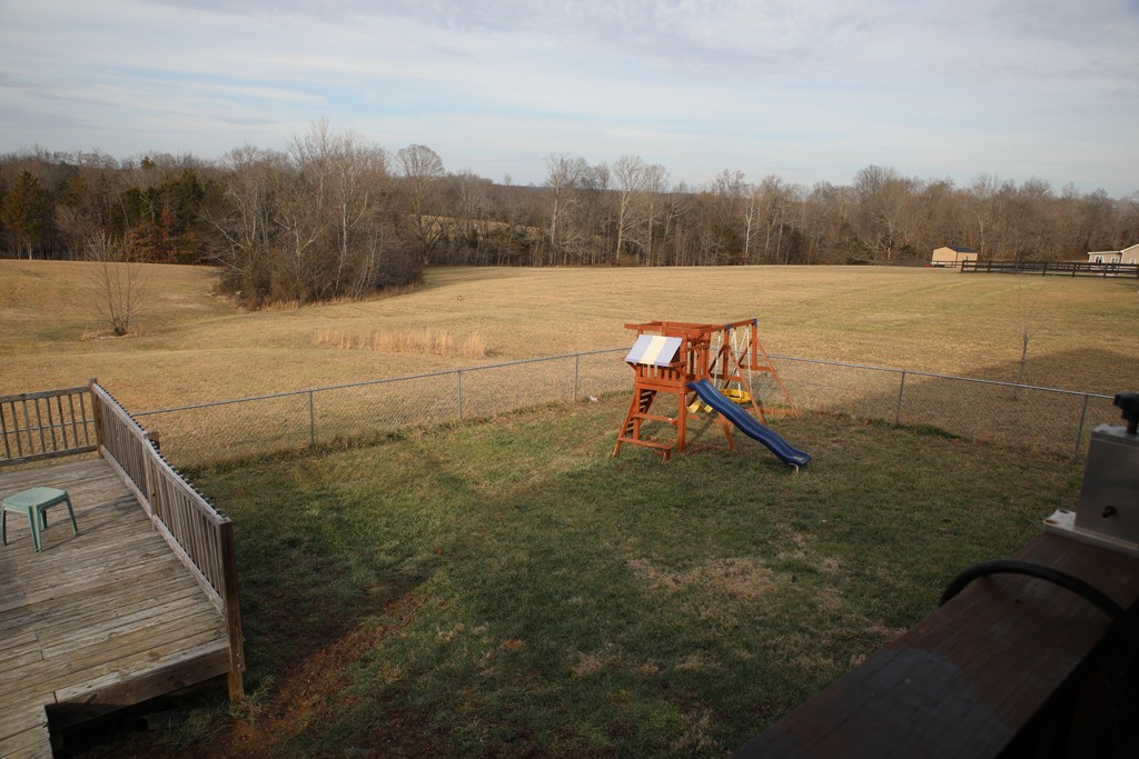 809 Hooper Road Charlotte, TN 37036 - Photo 13 of 14 a view of a lake with a yard and wooden fence