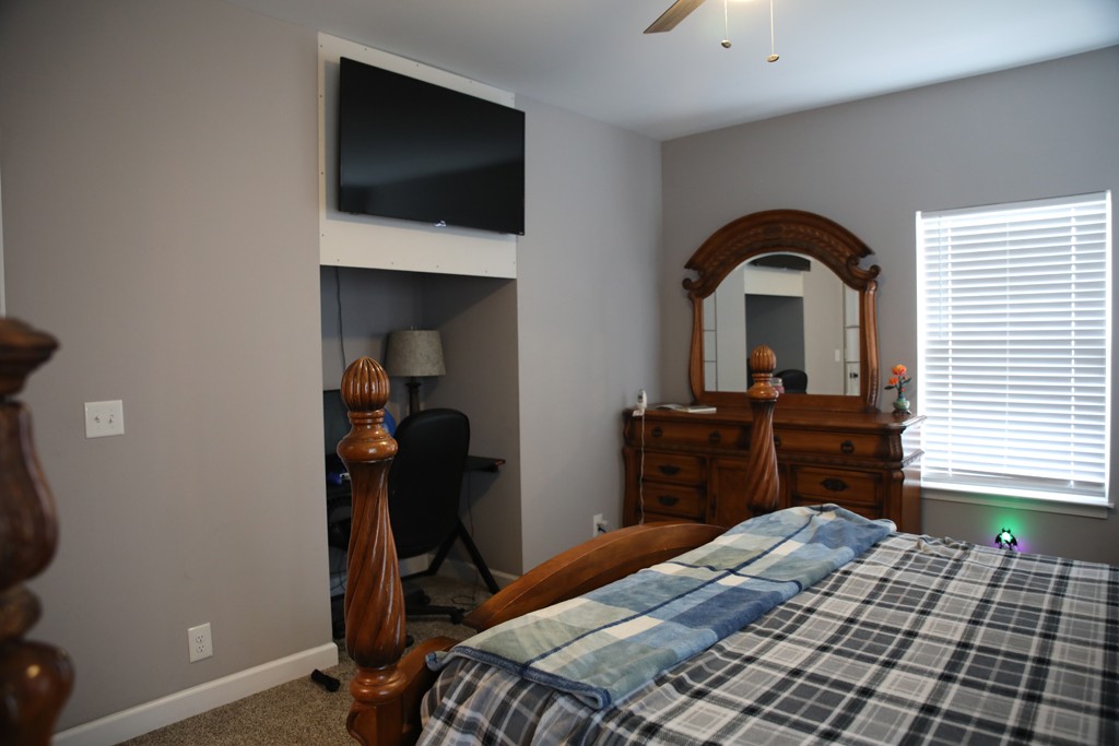 809 Hooper Road Charlotte, TN 37036 - Photo 10 of 14 a bedroom with a bed and a flat tv screen on dresser