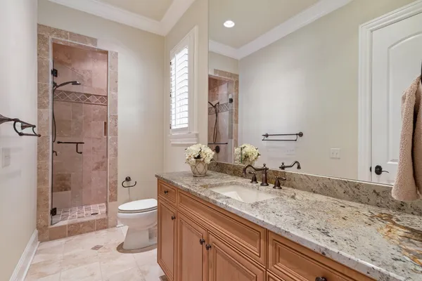 a bathroom with a granite countertop sink a mirror and a bathtub