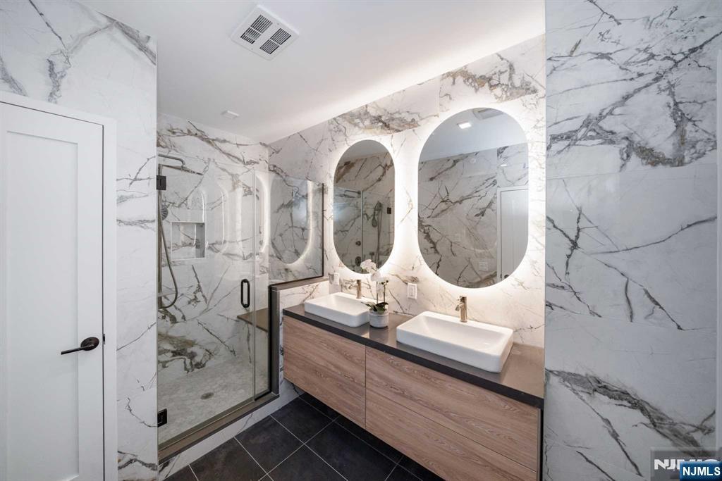 7101 River Road, Unit 304A North Bergen, NJ 07047 - Photo 11 of 24 a bathroom with a double vanity sink mirror and shower
