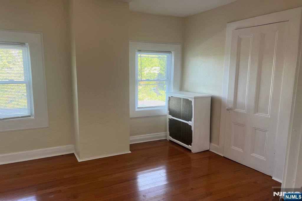 19 Spring Street, Unit 2 Bloomfield, NJ 07003 - Photo 16 of 19 an empty room with wooden floor cabinet and windows