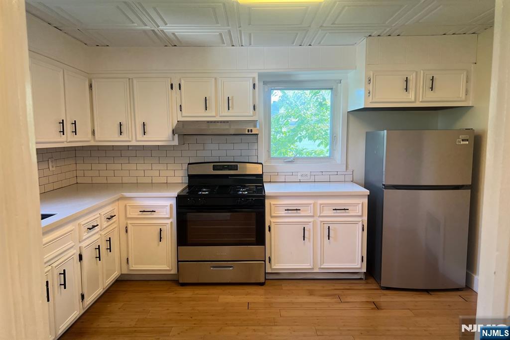 19 Spring Street, Unit 2 Bloomfield, NJ 07003 - Photo 9 of 19 a kitchen with white cabinets and refrigerator