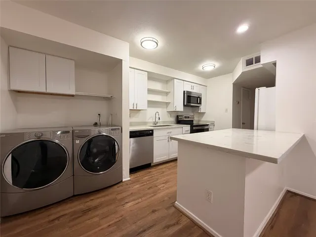 a kitchen with a stove top oven and cabinets