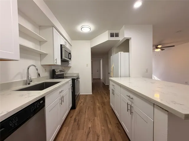 a large kitchen with a sink and cabinets