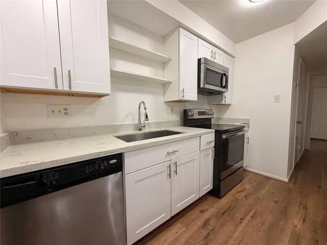 a kitchen with stainless steel appliances granite countertop a sink a stove a microwave and cabinets