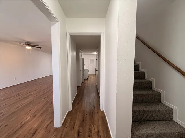 a view of a hallway with wooden floor and entryway