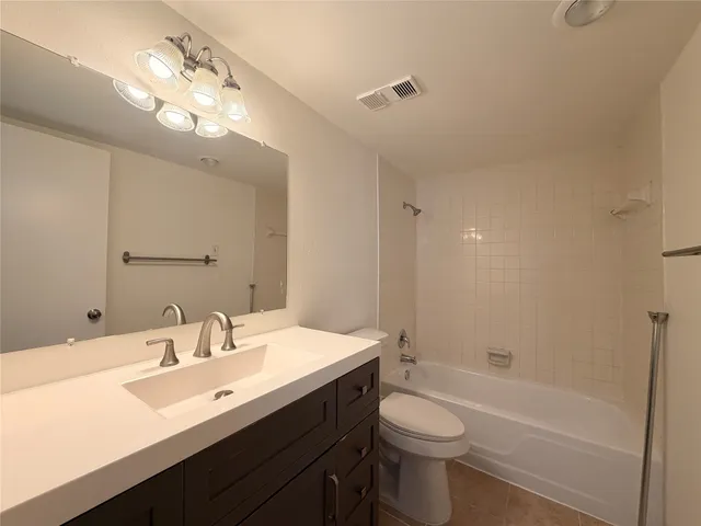 a bathroom with a sink a toilet a mirror a bathtub and shower