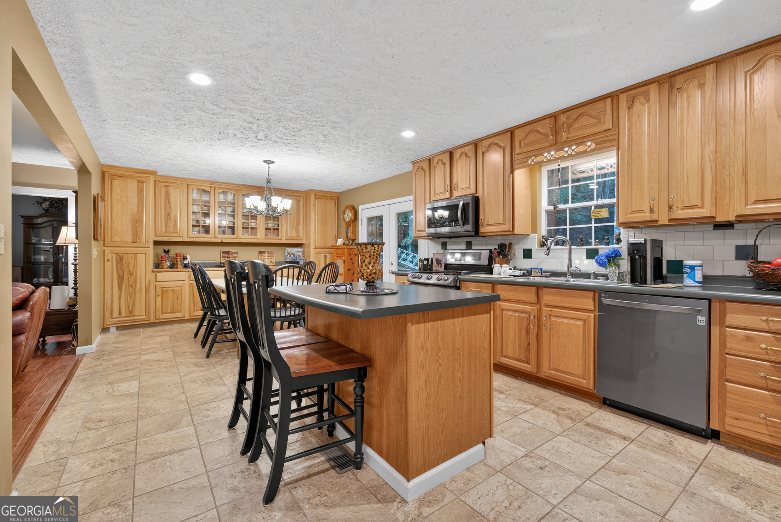 75 Juniper Trail Clayton, GA 30525 - Photo 9 of 38 a kitchen with stainless steel appliances kitchen island granite countertop a table chairs sink and cabinets