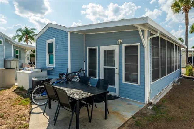 a view of a patio with table and chairs with wooden floor and fence