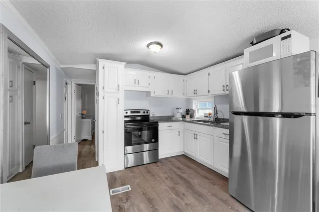 a kitchen with stainless steel appliances granite countertop a refrigerator sink and stove