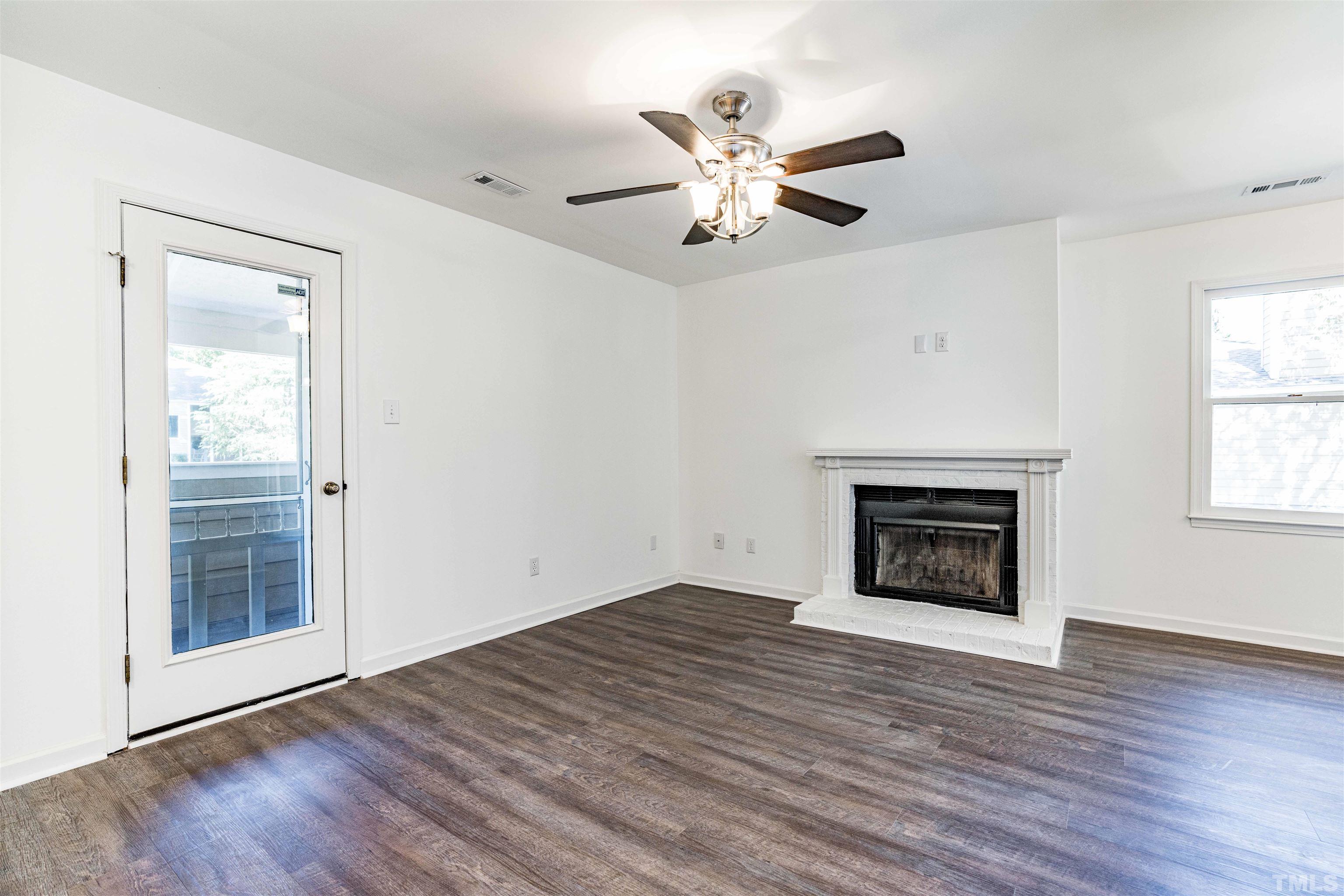3643 Mill Run, Unit 3643 Raleigh, NC 27612 - Photo 7 of 25 an empty room with wooden floor fan and windows