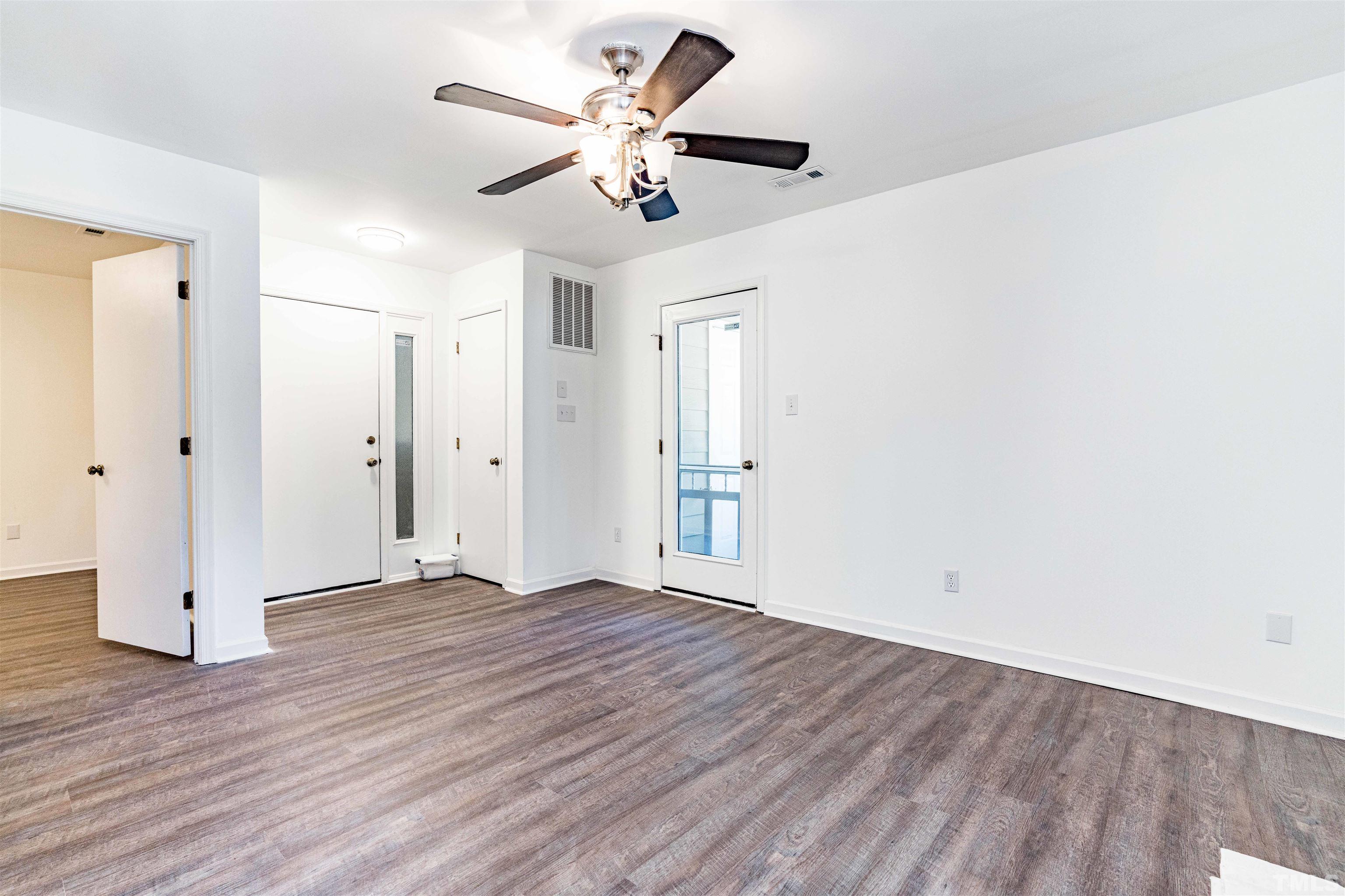 3643 Mill Run, Unit 3643 Raleigh, NC 27612 - Photo 8 of 25 an empty room with wooden floor and ceiling fan