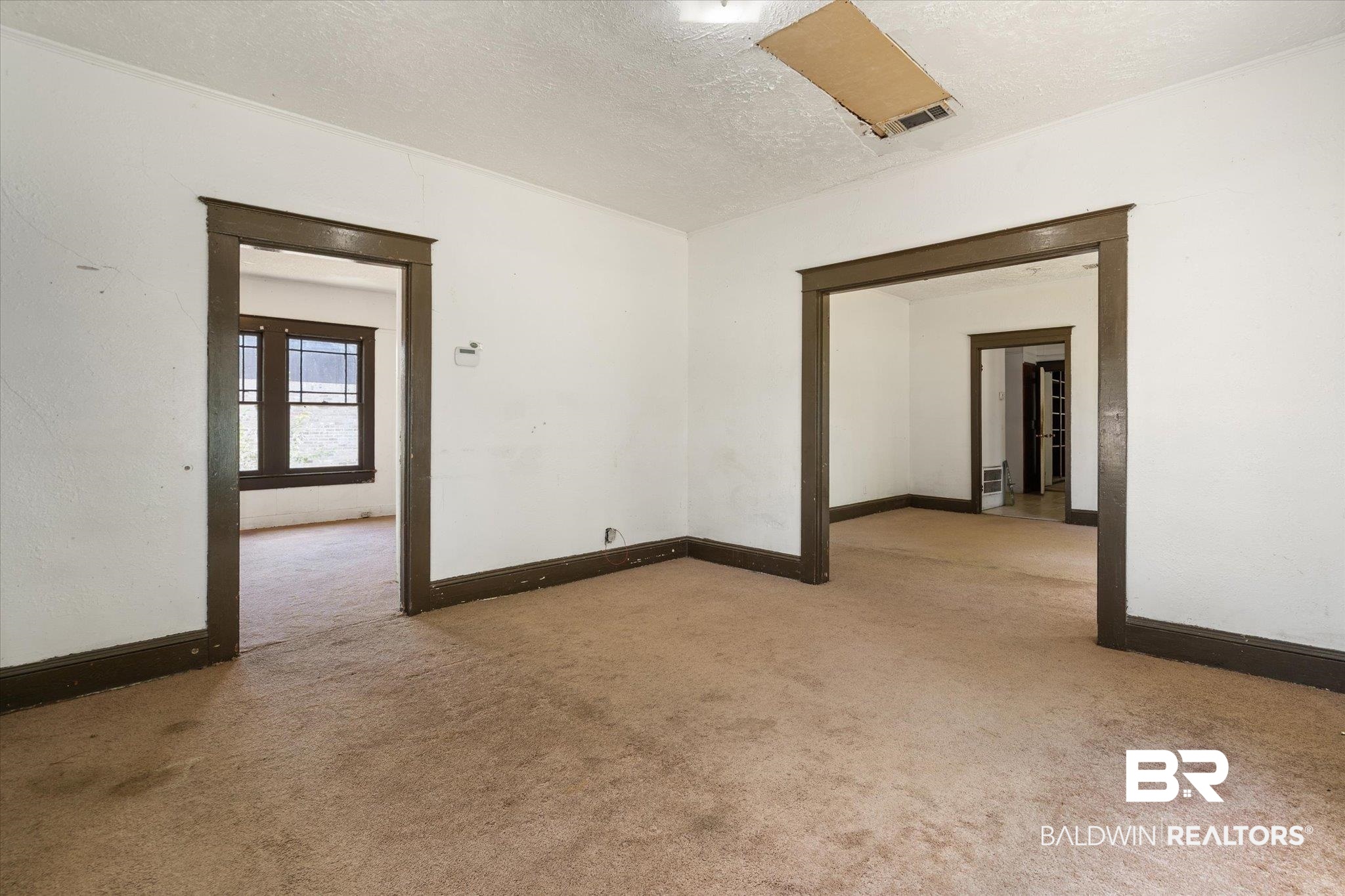 672 Burden Street Mobile, AL 36607 - Photo 3 of 20 Empty room with carpet floors, baseboards, and a textured ceiling